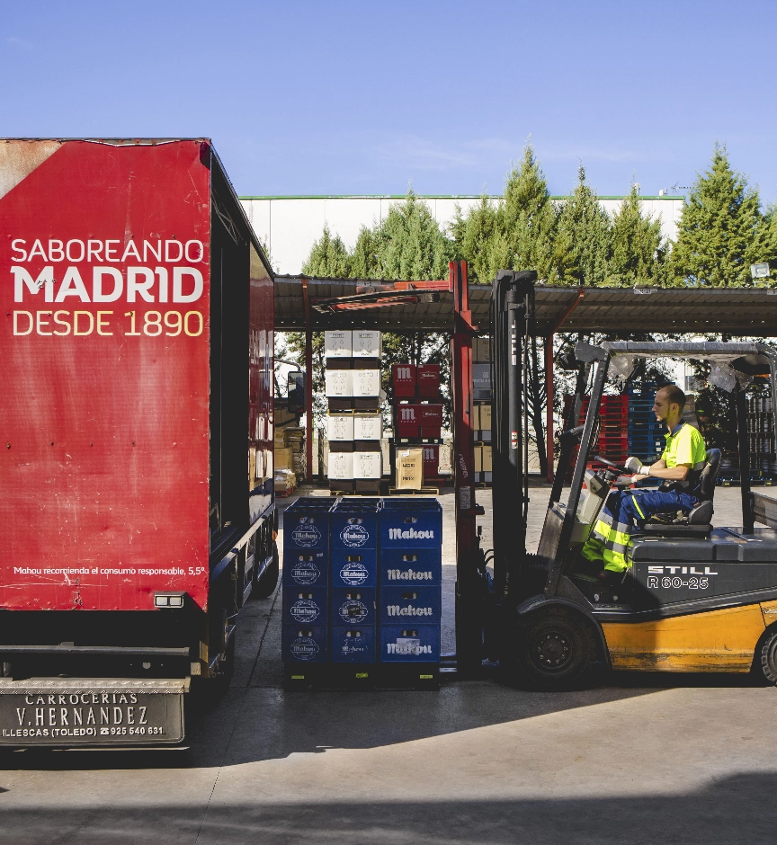 Una carretilla cargando un camión con cervezas